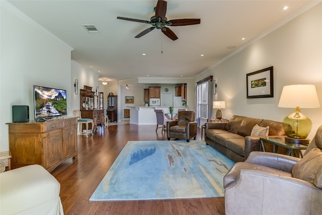 living room with dark hardwood / wood-style flooring, ceiling fan, and crown molding