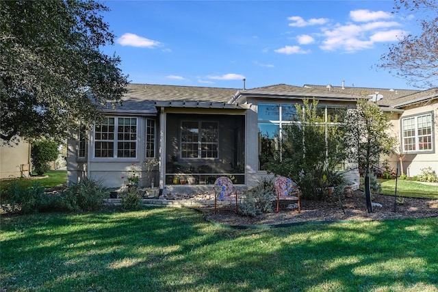 back of house featuring a lawn and a sunroom