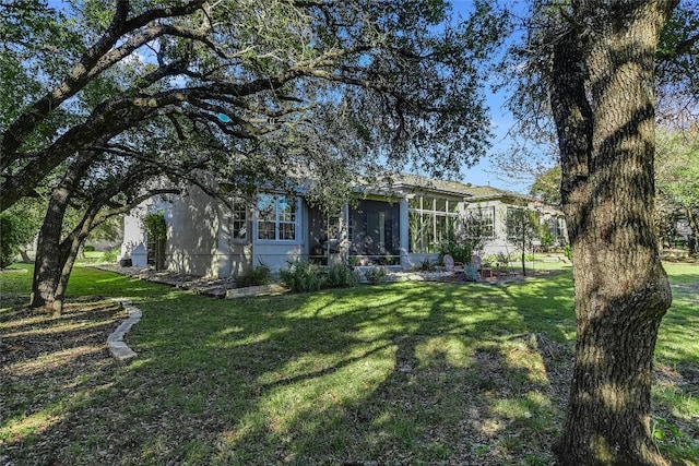 view of front of house with a sunroom and a front yard