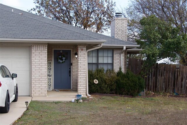 doorway to property with a yard and a garage