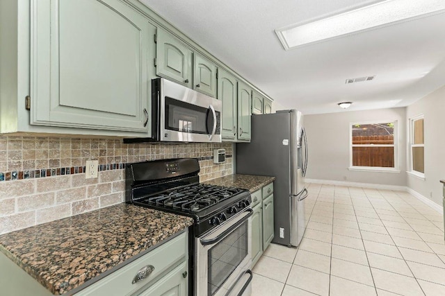 1807 Iris Ln, Cedar Park, TX 78613 - kitchen with stainless steel appliances, green cabinetry, backsplash, light tile patterned floors, and baseboards