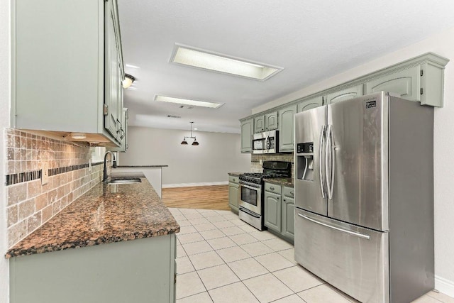 1807 Iris Ln, Cedar Park, TX 78613 - kitchen with appliances with stainless steel finishes, a sink, backsplash, baseboards, and light tile patterned floors