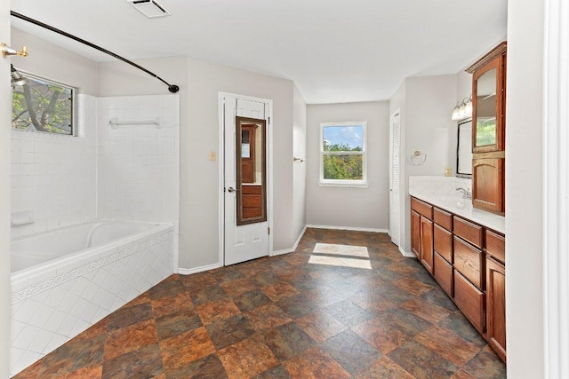1807 Iris Ln, Cedar Park, TX 78613 - full bath featuring healthy amount of natural light, vanity, tiled shower / bath combo, and stone finish flooring