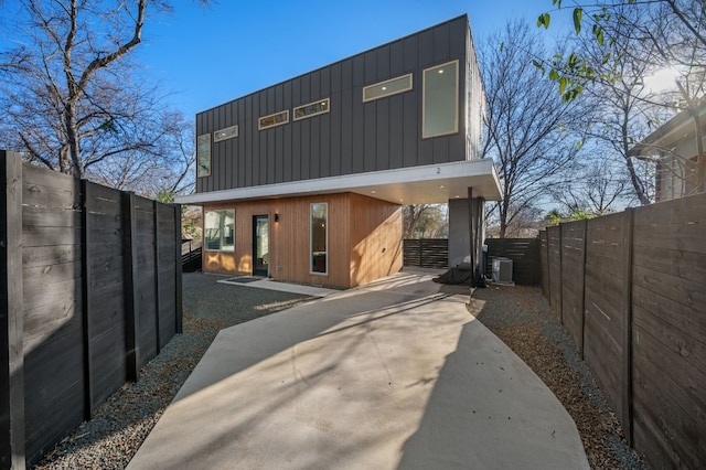 back of house featuring a carport and cooling unit