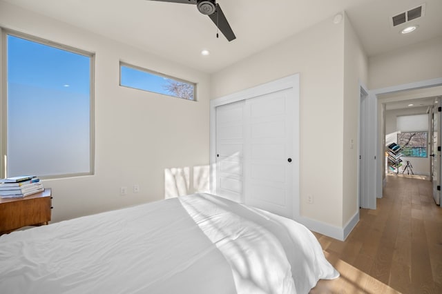 bedroom featuring hardwood / wood-style floors, ceiling fan, and a closet