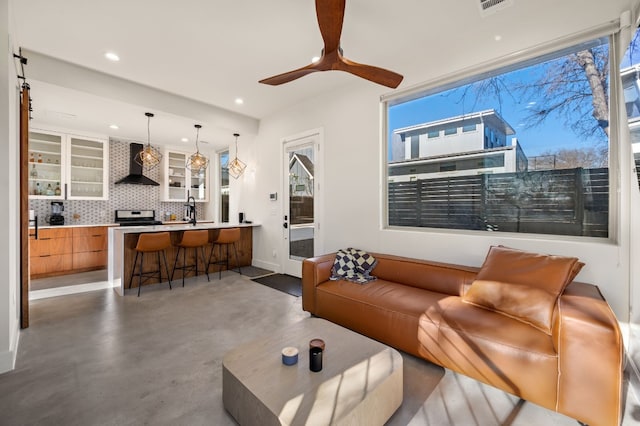 living room featuring ceiling fan and sink