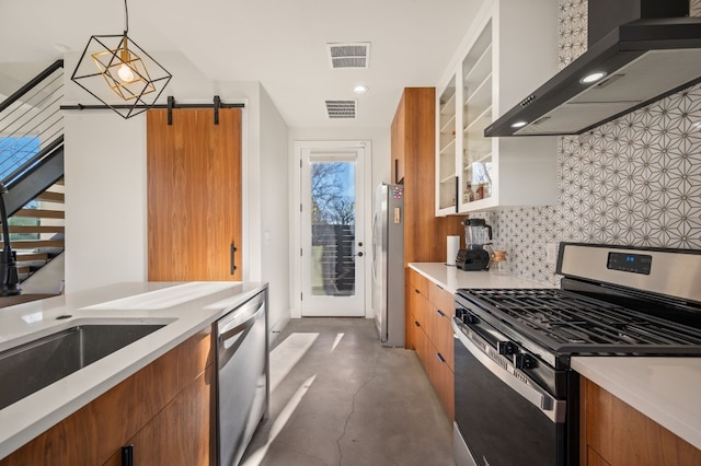 kitchen with appliances with stainless steel finishes, backsplash, sink, wall chimney range hood, and pendant lighting