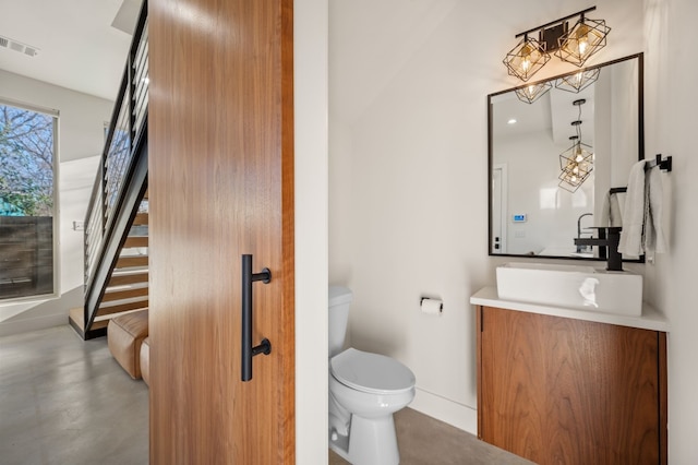 409 W Odell St Unit 2, Austin, TX 78752 - half bathroom featuring vanity, a chandelier, toilet, finished concrete floors, and baseboards