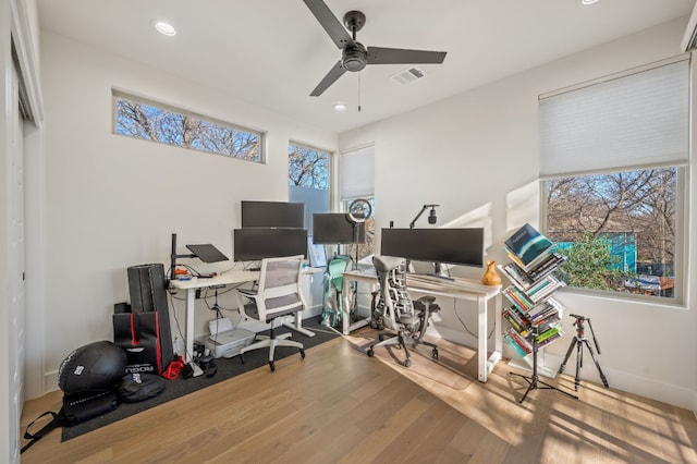 office with hardwood / wood-style flooring, ceiling fan, and a healthy amount of sunlight