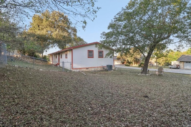 view of side of home featuring central AC and fence