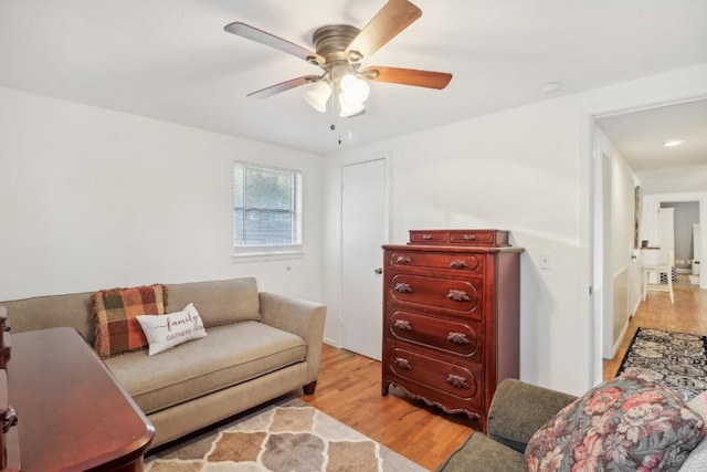 living area with light wood-type flooring and ceiling fan