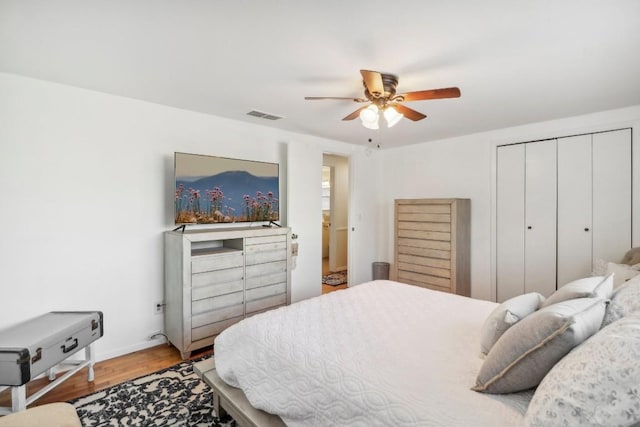 bedroom with hardwood / wood-style flooring, ceiling fan, and a closet