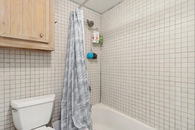 full bath featuring tile walls, toilet, and shower / tub combo