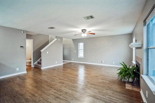 unfurnished living room with ceiling fan and dark wood-type flooring