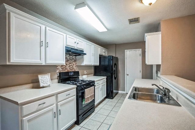 kitchen featuring black appliances, sink, decorative backsplash, light tile patterned floors, and white cabinetry