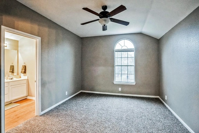 carpeted spare room with ceiling fan and lofted ceiling