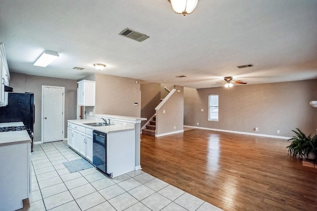 kitchen featuring ceiling fan, sink, dishwasher, white cabinets, and light tile patterned flooring