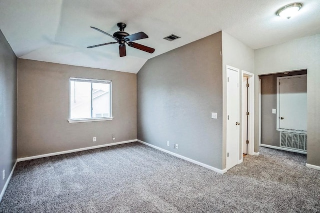 spare room featuring ceiling fan, carpet, and vaulted ceiling