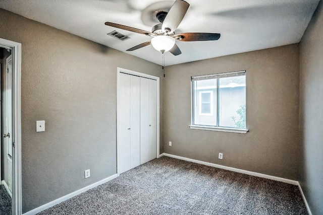 unfurnished bedroom with ceiling fan, a closet, and carpet floors