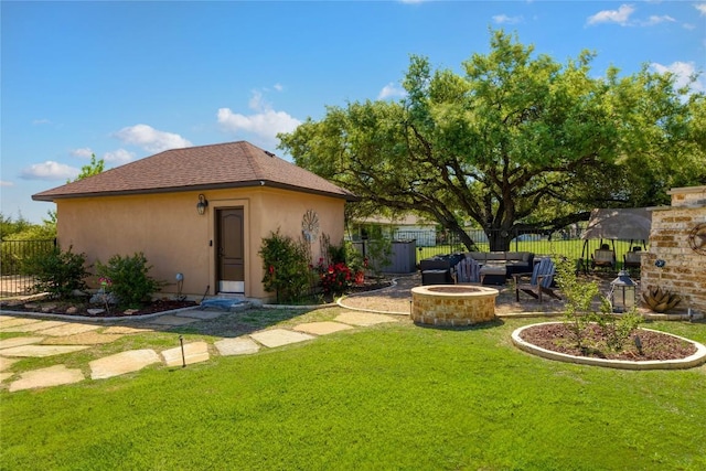 view of yard with an outdoor living space with a fire pit, an outbuilding, fence, and a patio area