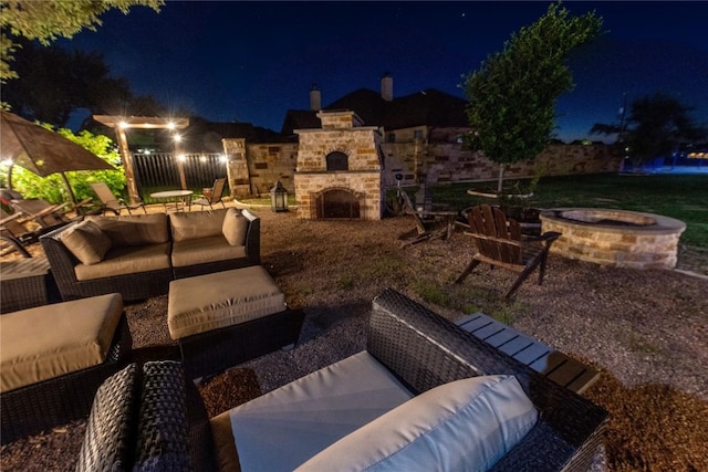 patio at twilight with an outdoor living space with a fireplace