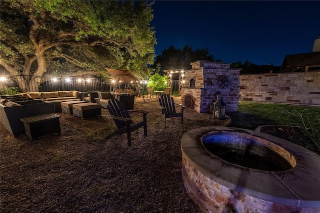 yard at twilight with a fenced backyard and an outdoor living space with a fire pit