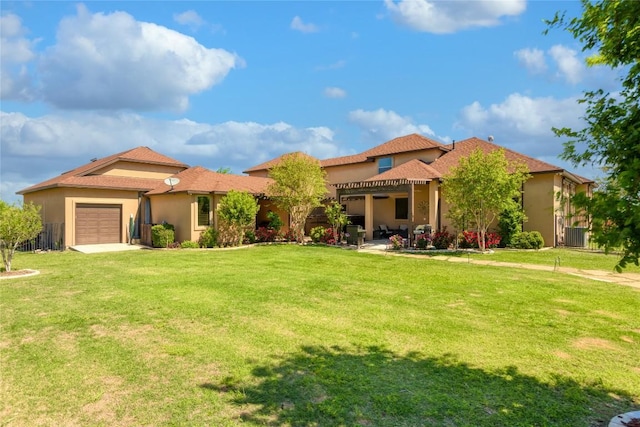 mediterranean / spanish-style home featuring a front yard, an attached garage, driveway, and stucco siding