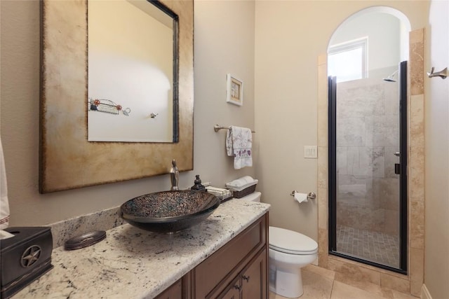 full bathroom featuring tile patterned floors, a stall shower, toilet, and vanity