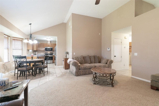 living room with ceiling fan with notable chandelier, light colored carpet, and high vaulted ceiling