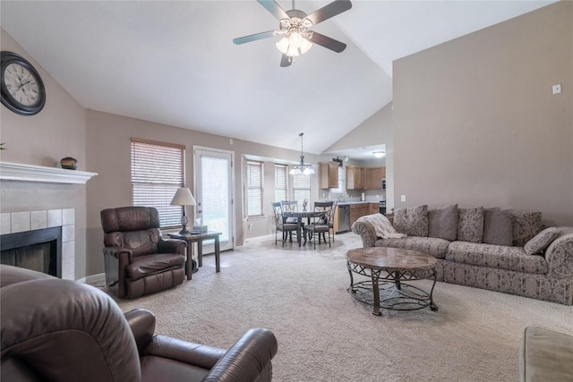 living room with ceiling fan, lofted ceiling, light carpet, and a tiled fireplace