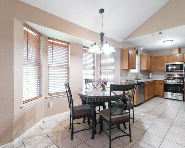 tiled dining area featuring sink, a chandelier, and vaulted ceiling