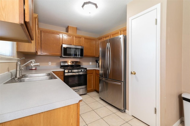 kitchen with appliances with stainless steel finishes, light tile patterned floors, and sink