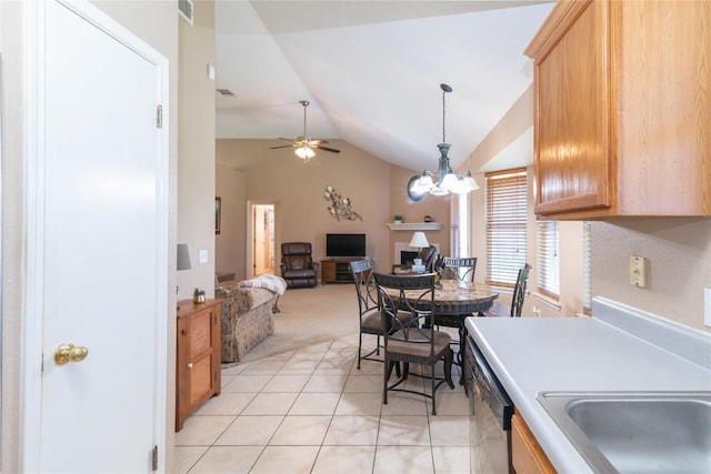 kitchen with light carpet, ceiling fan with notable chandelier, vaulted ceiling, pendant lighting, and dishwasher