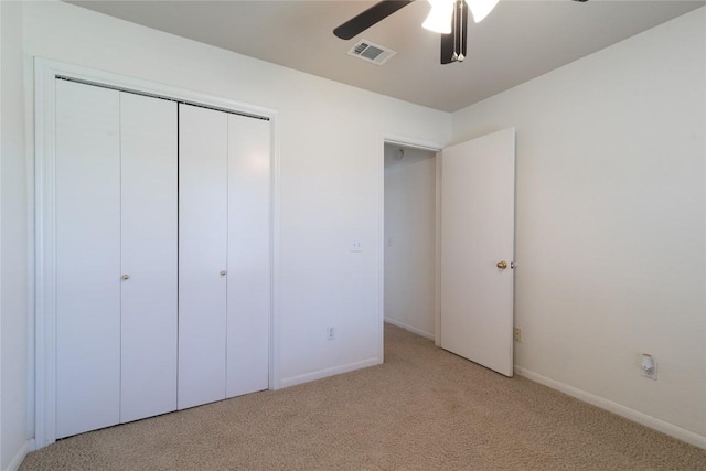 unfurnished bedroom featuring ceiling fan, a closet, and light carpet