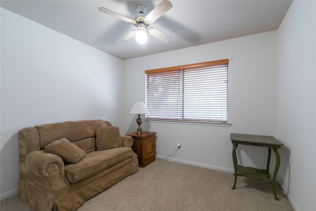 living area featuring light colored carpet and ceiling fan