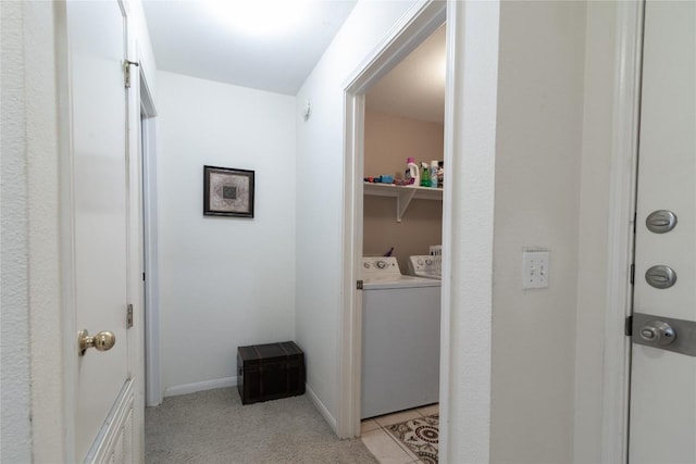 hallway with light tile patterned floors and separate washer and dryer