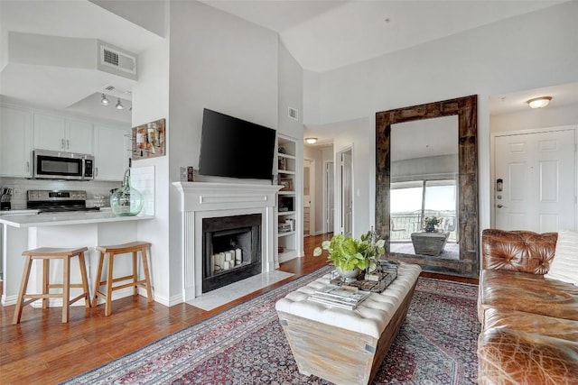 living room with built in features and light hardwood / wood-style flooring