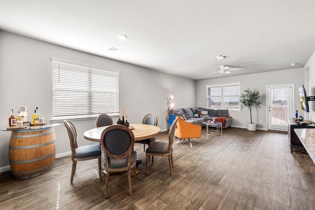 dining space with dark hardwood / wood-style floors and ceiling fan