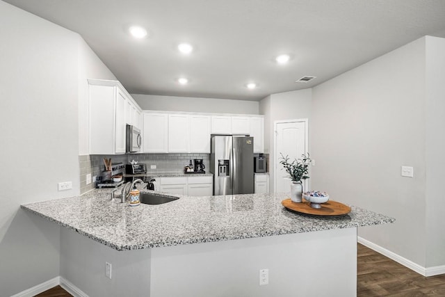 kitchen featuring white cabinets, stainless steel appliances, kitchen peninsula, and sink