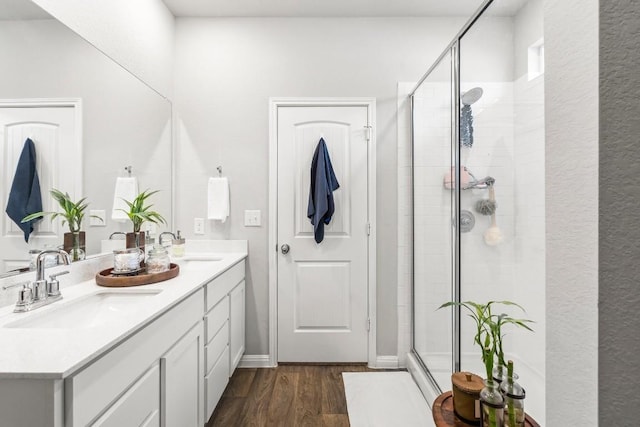 bathroom featuring vanity, wood-type flooring, and a shower with shower door