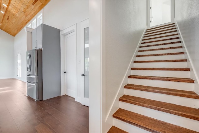 stairway featuring hardwood / wood-style floors, wooden ceiling, and lofted ceiling