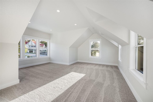 bonus room featuring light carpet, vaulted ceiling, and plenty of natural light