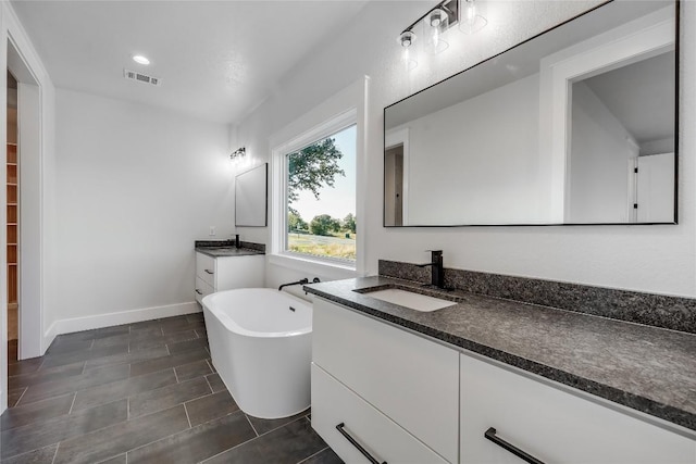 bathroom with vanity and a tub