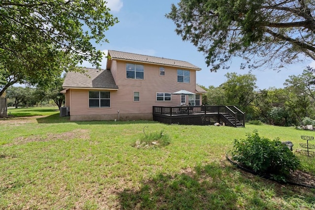 back of property with central AC unit, a lawn, and a wooden deck