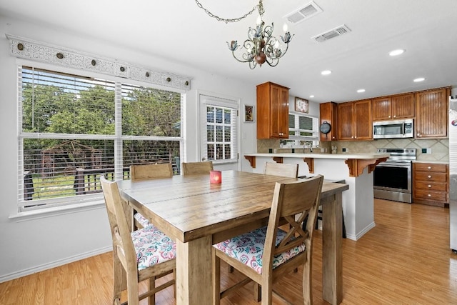 dining area featuring light hardwood / wood-style floors and a notable chandelier