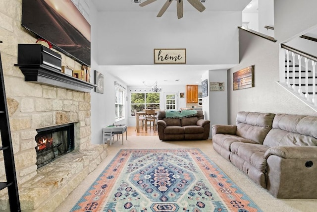 living room with a stone fireplace and ceiling fan