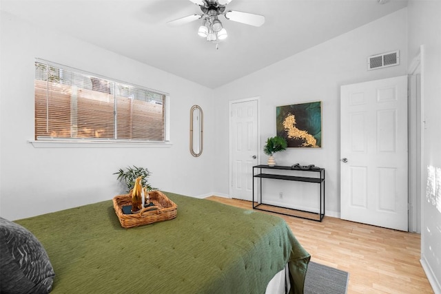 bedroom with ceiling fan, vaulted ceiling, and hardwood / wood-style flooring