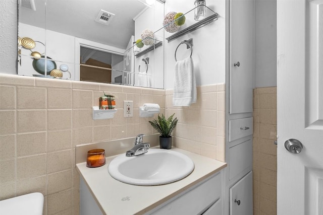 bathroom with vanity, tile walls, and backsplash