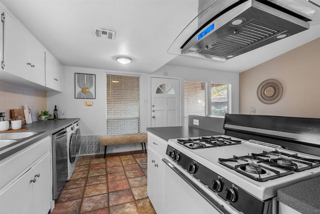 kitchen with backsplash, exhaust hood, white cabinets, white gas range oven, and washer / clothes dryer