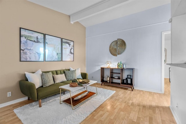 living room featuring lofted ceiling with beams and light hardwood / wood-style flooring